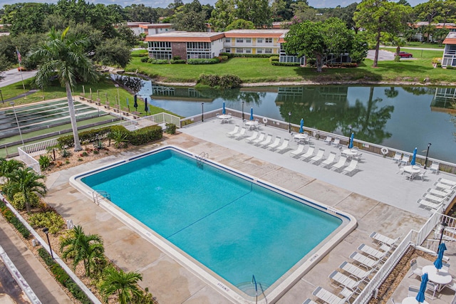 view of pool featuring a water view, a yard, and a patio area