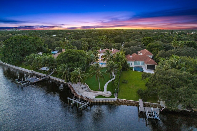 aerial view at dusk featuring a water view