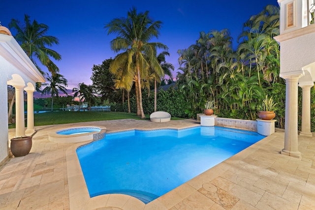 pool at dusk featuring an in ground hot tub and a patio area