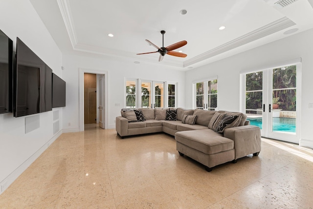 living room featuring a raised ceiling, ceiling fan, ornamental molding, and french doors