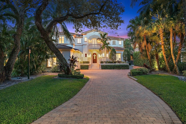 mediterranean / spanish house featuring a yard