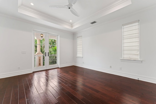 spare room featuring crown molding, dark wood-type flooring, ceiling fan, a tray ceiling, and french doors