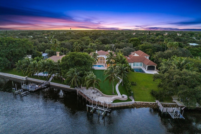 aerial view at dusk featuring a water view