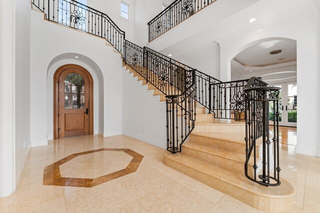 13058 Flamingo Ter, Palm Beach Gardens, FL 33410 - entrance foyer with baseboards, inlaid floor details, arched walkways, plenty of natural light, and a high ceiling