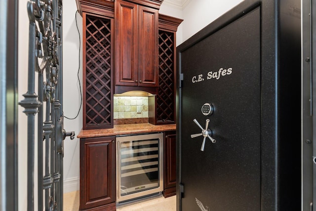 wine cellar featuring ornamental molding, wine cooler, and bar