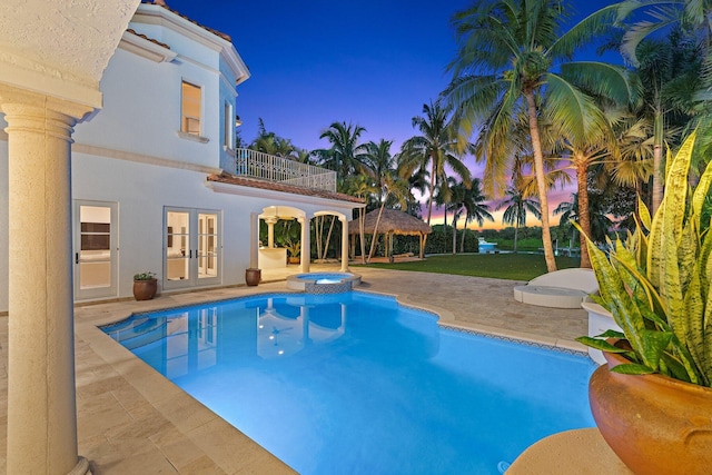 pool at dusk featuring a gazebo, a patio area, an in ground hot tub, and french doors