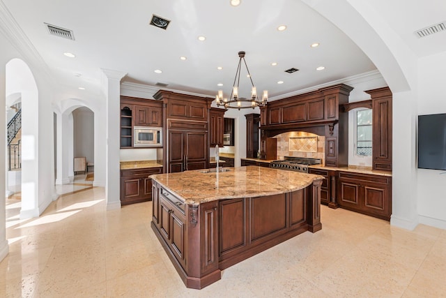 kitchen with built in appliances, crown molding, sink, a chandelier, and a large island