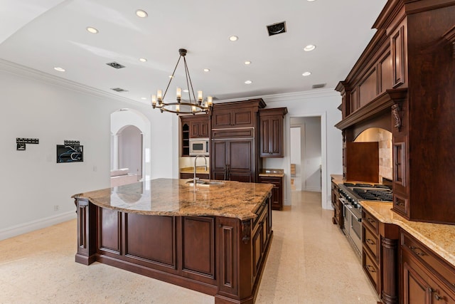 kitchen with built in appliances, a spacious island, an inviting chandelier, sink, and light stone countertops