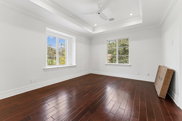 unfurnished room featuring ceiling fan, ornamental molding, dark hardwood / wood-style floors, and a tray ceiling