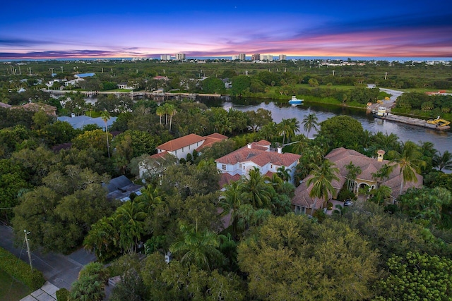 aerial view at dusk featuring a water view