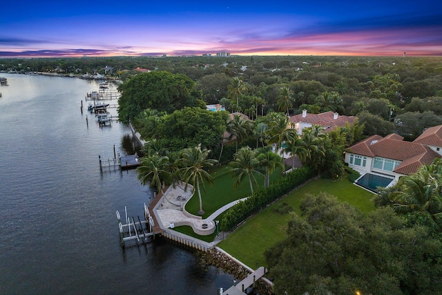 aerial view at dusk featuring a water view