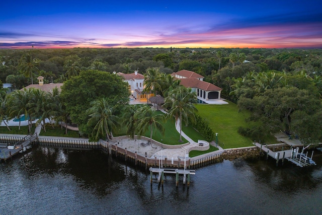 aerial view at dusk featuring a water view