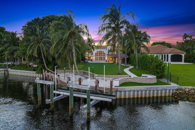 dock area with a lawn and a water view