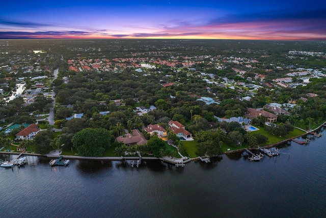 aerial view at dusk featuring a water view