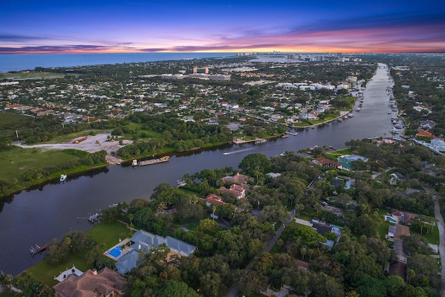 aerial view at dusk featuring a water view