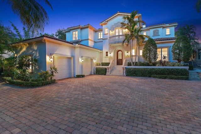 13058 Flamingo Ter, Palm Beach Gardens, FL 33410 - mediterranean / spanish house featuring a balcony, stucco siding, decorative driveway, a garage, and a tiled roof
