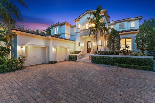 13058 Flamingo Ter, Palm Beach Gardens, FL 33410 - mediterranean / spanish house featuring a balcony, stucco siding, decorative driveway, a garage, and a tiled roof