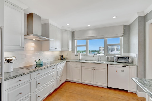 kitchen featuring white cabinetry, sink, wall chimney range hood, white dishwasher, and black electric cooktop