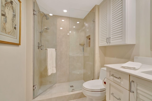 bathroom with a shower with door, vanity, and toilet