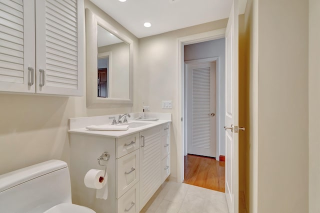 bathroom featuring wood-type flooring, vanity, and toilet