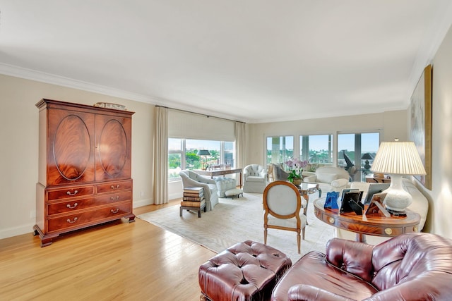 living room with crown molding, plenty of natural light, and light hardwood / wood-style floors