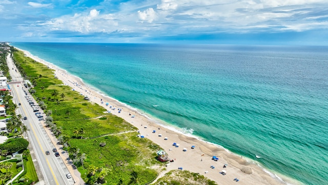 birds eye view of property with a water view and a beach view