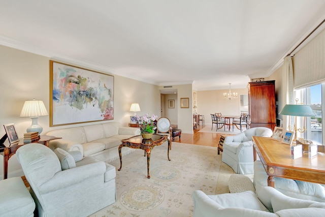 living room featuring light hardwood / wood-style flooring, ornamental molding, and a notable chandelier