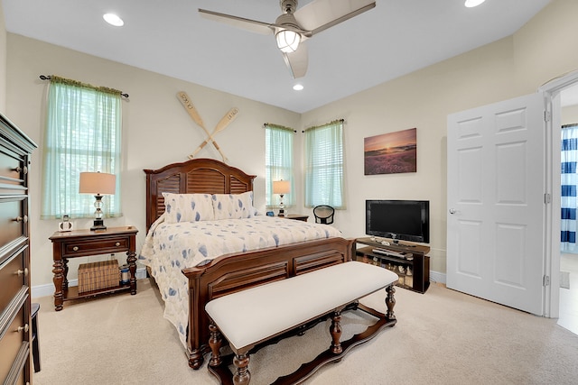 carpeted bedroom featuring ceiling fan and multiple windows