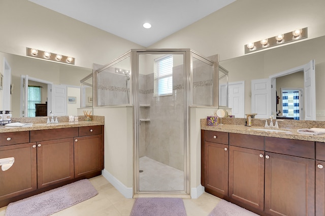 bathroom with tile patterned flooring, a shower with shower door, and vanity