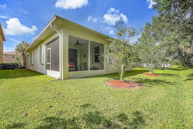 back of property with ceiling fan and a lawn