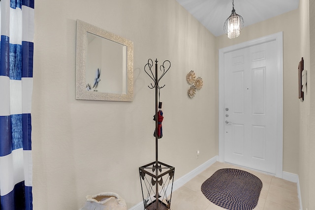 entryway with an inviting chandelier and light tile patterned floors