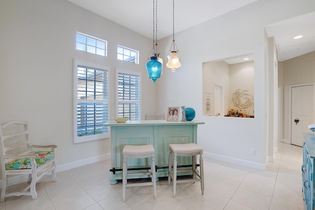 dining room with a towering ceiling and light tile patterned flooring