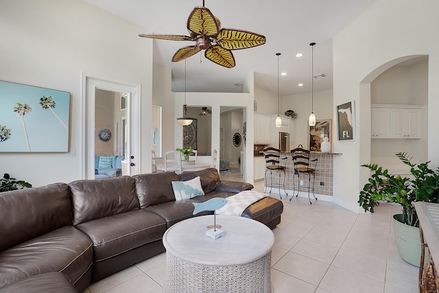 tiled living room with a towering ceiling and ceiling fan