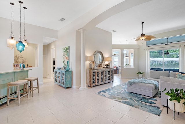 tiled living room featuring decorative columns and ceiling fan