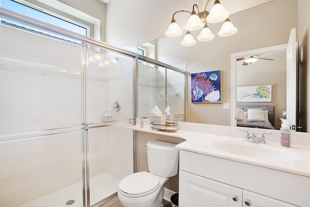 bathroom featuring vanity, ceiling fan with notable chandelier, an enclosed shower, and toilet