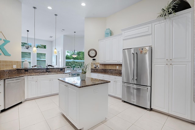 kitchen featuring stainless steel appliances, dark stone counters, and white cabinets