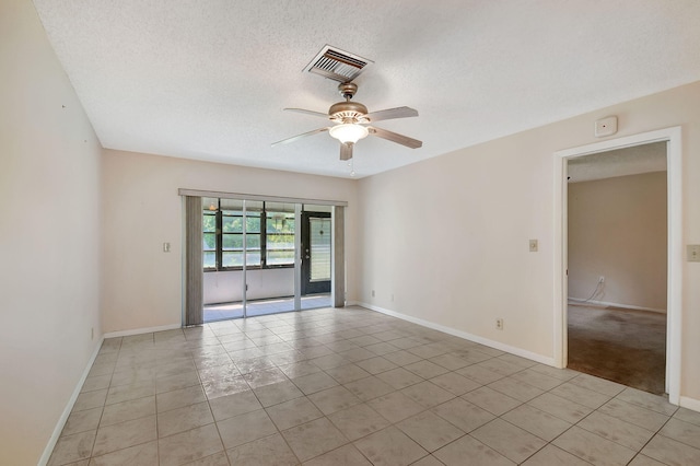 tiled spare room with a textured ceiling and ceiling fan