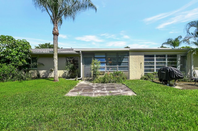 rear view of house featuring a yard and a patio