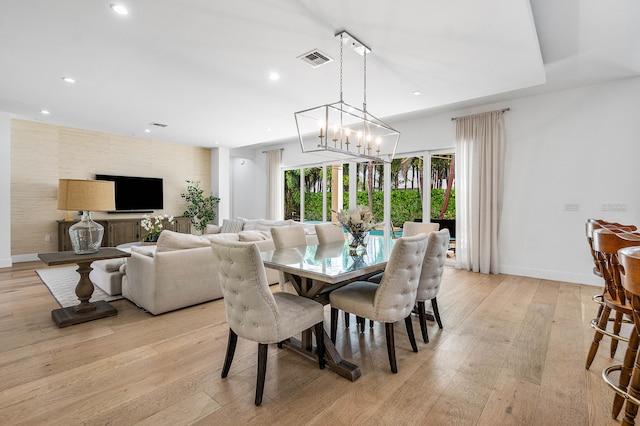 dining area featuring light hardwood / wood-style floors and an inviting chandelier