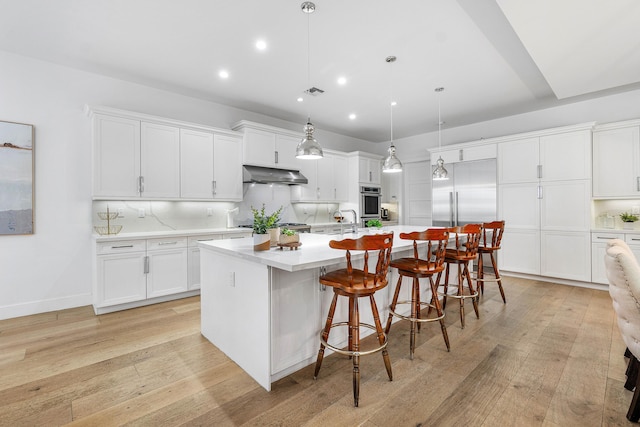 200 NE 6th Ct, Boca Raton, FL 33432 - kitchen featuring under cabinet range hood, built in fridge, light countertops, light wood finished floors, and recessed lighting