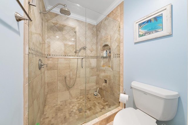 bathroom featuring crown molding, toilet, and tiled shower