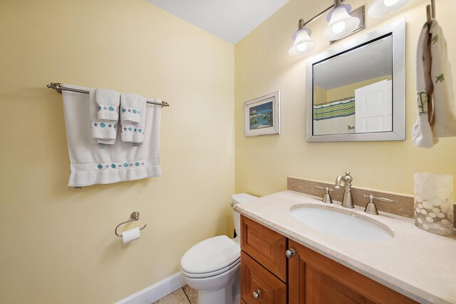 bathroom featuring tile patterned flooring, vanity, and toilet