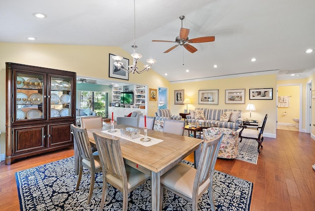 dining room featuring hardwood / wood-style flooring, ceiling fan with notable chandelier, and lofted ceiling