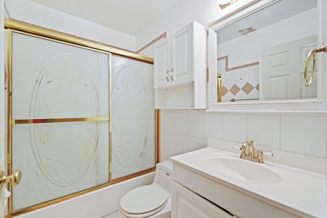 full bathroom with vanity, toilet, tile walls, and enclosed tub / shower combo