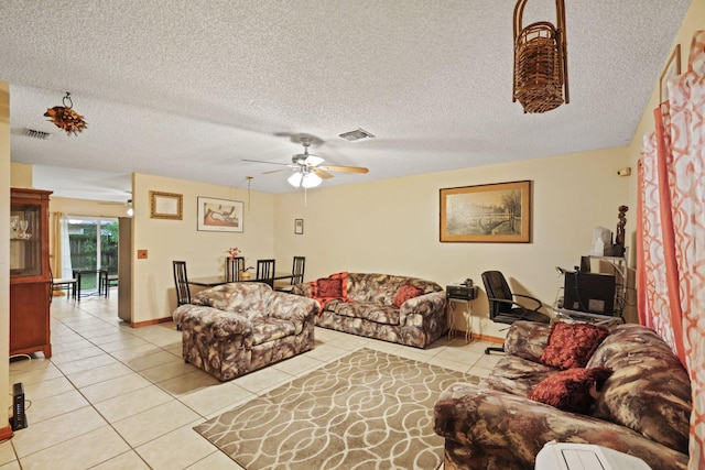 living room featuring a textured ceiling, light tile patterned floors, and ceiling fan