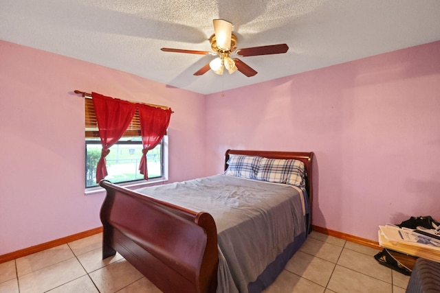 tiled bedroom with a textured ceiling and ceiling fan