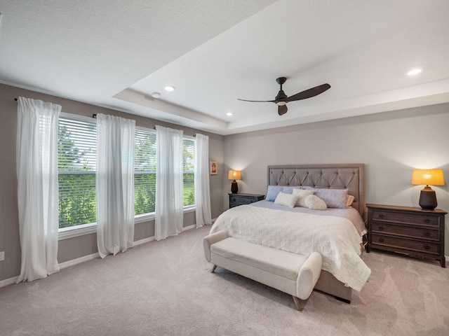 bedroom featuring light colored carpet, ceiling fan, and multiple windows