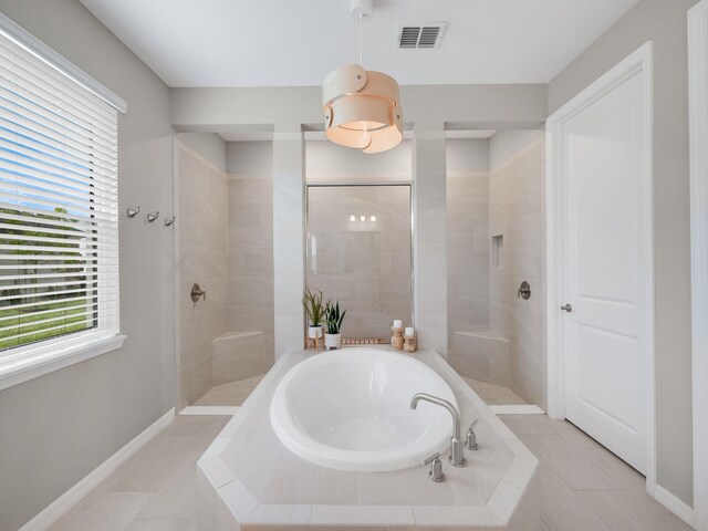 bathroom featuring tile patterned flooring and shower with separate bathtub