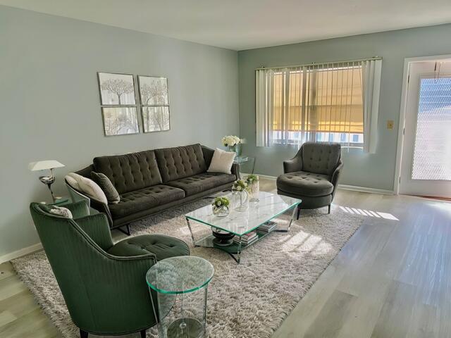 living area with baseboards and wood finished floors