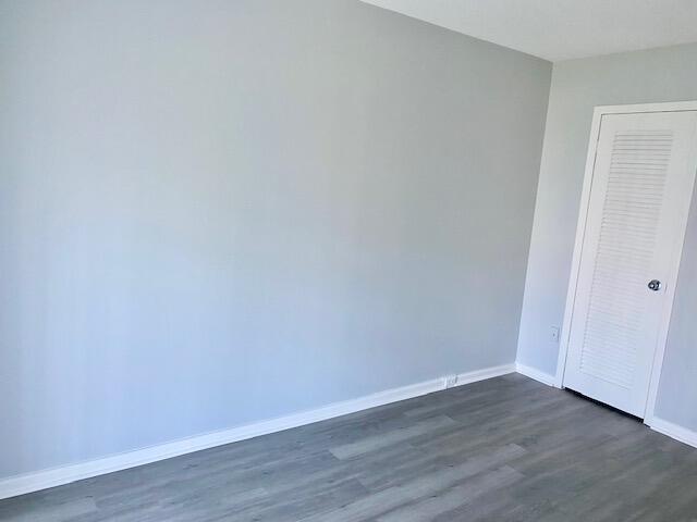 unfurnished bedroom with a closet and dark hardwood / wood-style flooring